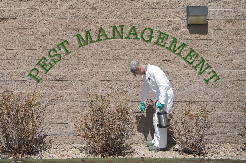 Airman Steven R. Ewell, 460th Civil Engineer pest management apprentice, sprays the Panther Hall Dormitories for ants Ap
